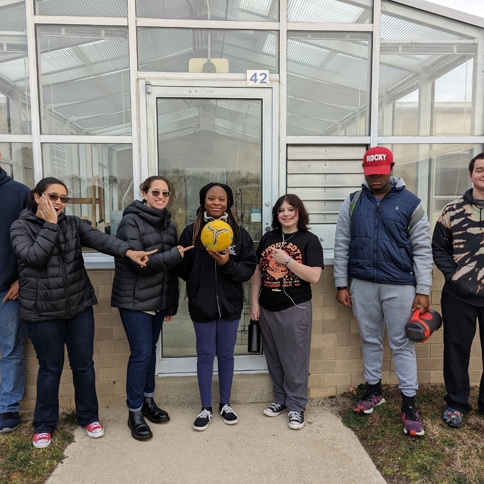 Science club students outside with a soccer ball representing the Sun.